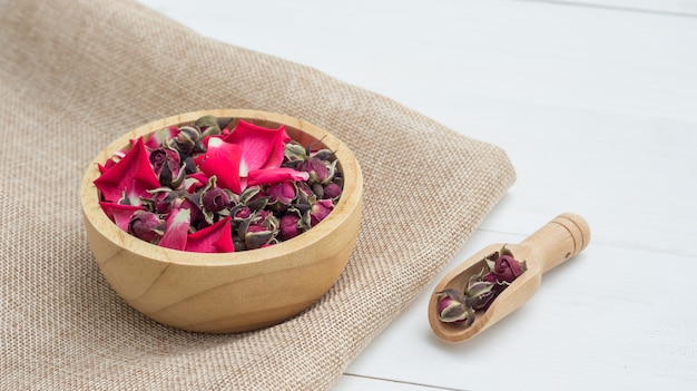 Sucha herbaciana menchii róża na białym drewnianym stole.