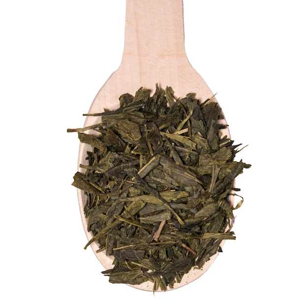 Sucha herbata Sencha w drewnianej łyżce na białym tle