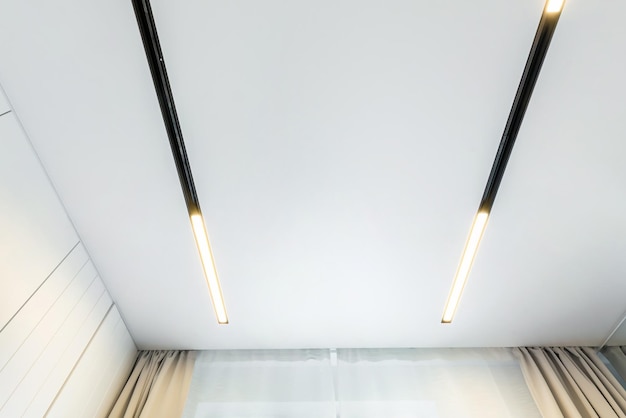 Zdjęcie sufit podwieszany z punktowymi lampami halogenowymi i płytą gipsowo-kartonową w pustym pomieszczeniu w mieszkaniu lub domu sufit napinany biały i złożony kształt
