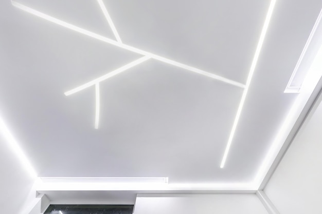 Sufit podwieszany z punktowymi lampami halogenowymi i płytą gipsowo-kartonową w pustym pomieszczeniu w mieszkaniu lub domu Sufit napinany biały i złożony kształt