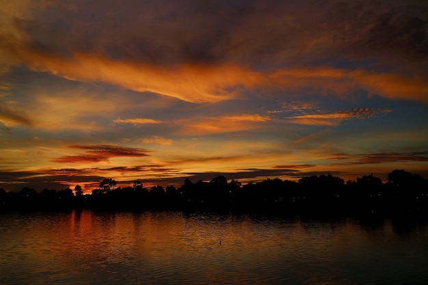 Sunset Paradise z wioską chmur z czerwonym i niebieskim niebem i odbiciem nad rzeką