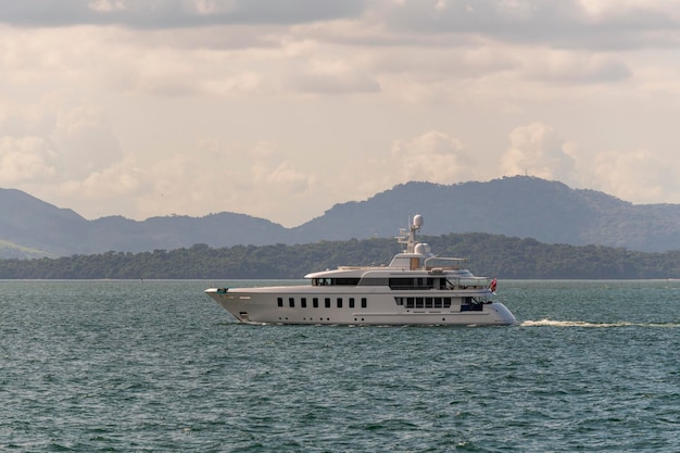 Super luksusowy jacht z białym kadłubem z miastem Panama w tle