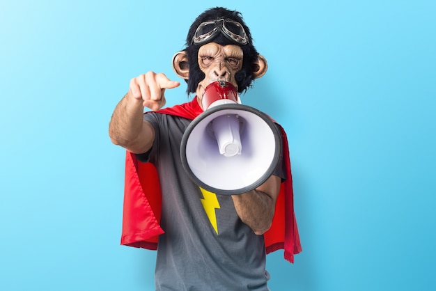 Superhero mężczyzna małpy krzycząc przez megafon na kolorowe tło