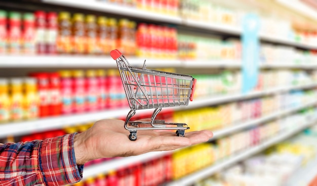Supermarket Spożywczy Tło Z Wózkiem W Ręku Jedzenie I Artykuły Spożywcze Zamazane Na Półkach Sklepowych
