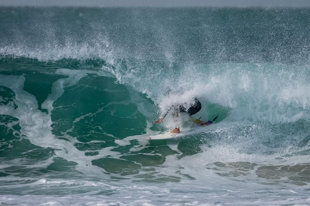 Surfer jeździ na falach podczas turnieju surfingu Super Tubes w Jeffreys Bay w Południowej Afryce