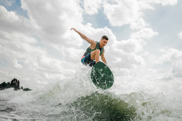 Surfer kaukaski jazda wakeboard na wysokiej fali