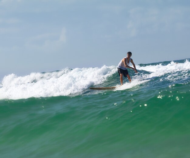 Surfer na longboard jedzie fala w morzu