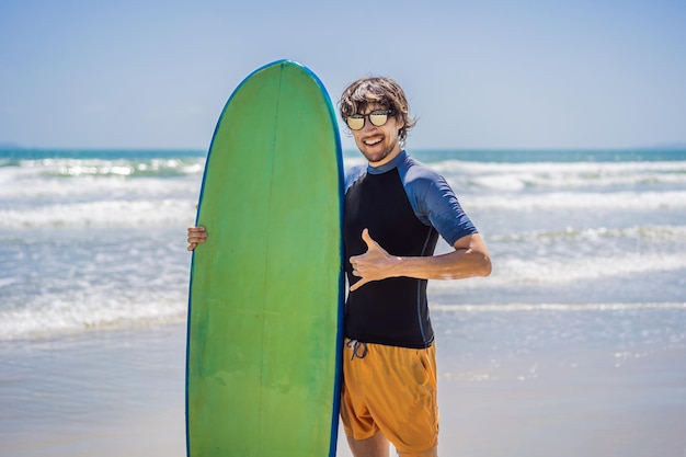 Surfer trzyma deskę surfingową na plaży