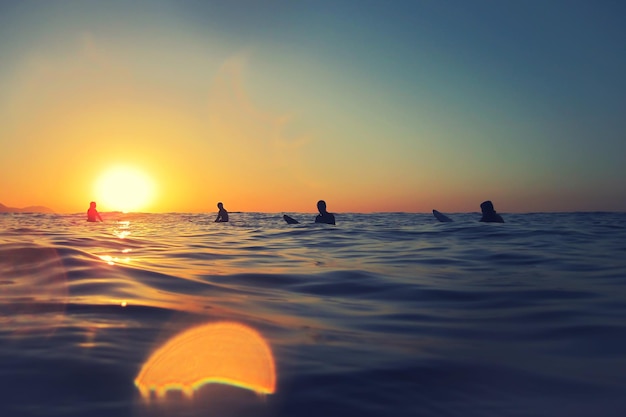 Surferzy patrzą na zachód słońca