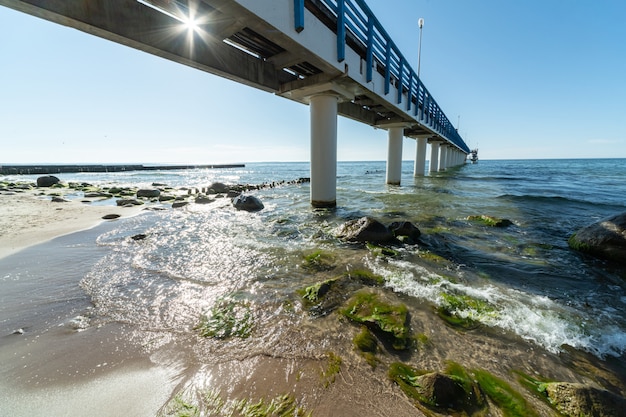 Zdjęcie surfuj fale z pianką morską i wodorostami na plaży turystycznej