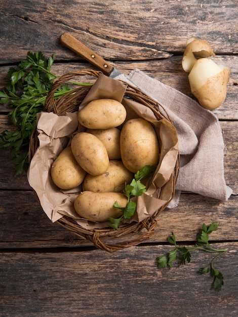 Surowa organicznie grula z pietruszką w koszu na drewnianym stołowym odgórnym widoku