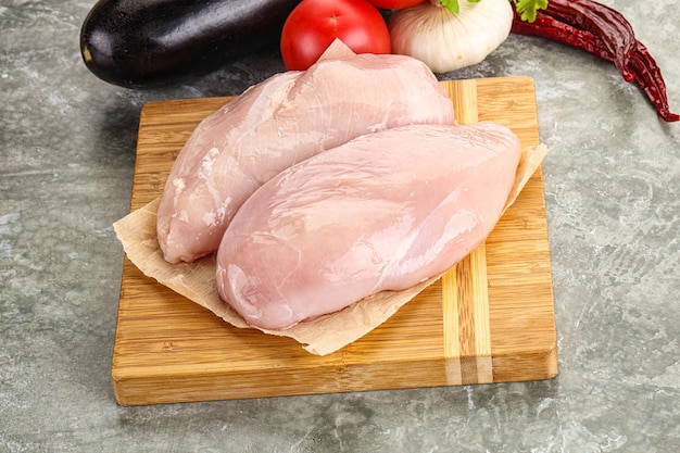 Surowa pierś z kurczaka na desce do gotowania