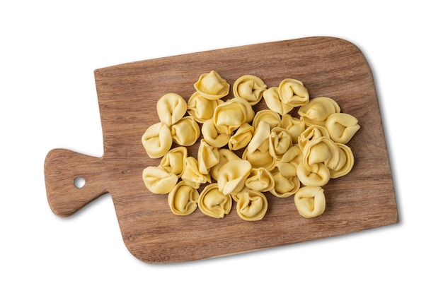 Surowe cappelletti lub tortellini na desce odizolowanej na białym tle