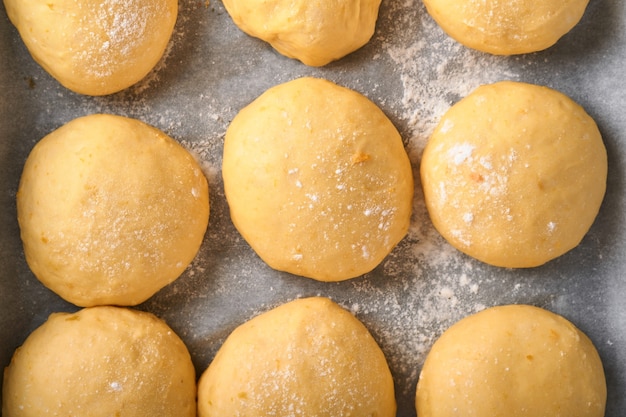 Surowe ciasto drożdżowe kulki tło na patelni przed pieczeniem. Koncepcja domowego pieczenia chleba, bułek lub cynabonu lub robienia ciasta.