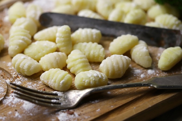 Surowe gnocchi na drewnianej desce.