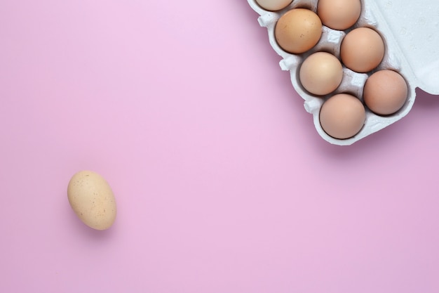 Surowe jaja kurze żywność ekologiczna na dobre zdrowie wysokiej białka na różowym tle. jajka - widok z góry