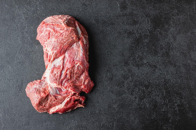 Surowe mięso wołowe na czarnym stole
