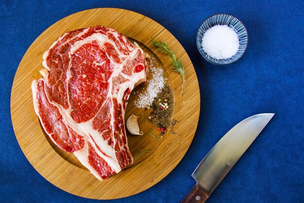 Zdjęcie surowe mięso wołowe na stole przyprawy i rosmaryn składniki steku