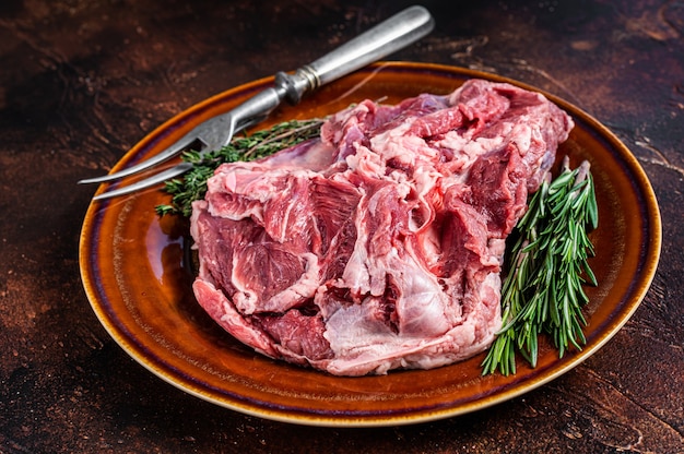 Surowe mięso z nogi jagnięcej bez kości w rustykalnym talerzu z tymiankiem