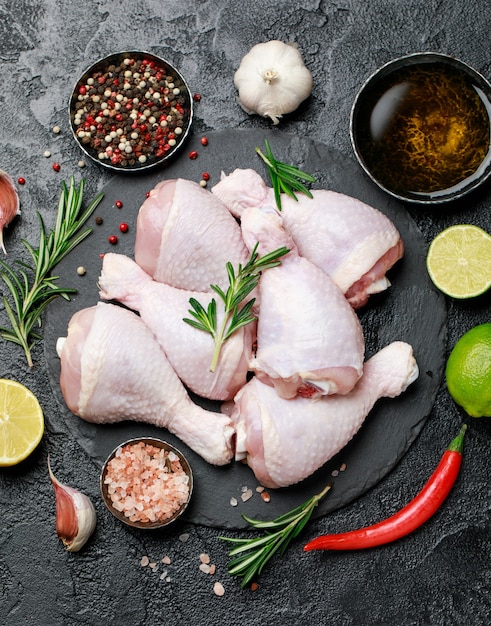 Surowe, Niegotowane Udka Z Kurczaka Z Przyprawami I Składnikami Do Gotowania Na Desce Do Krojenia