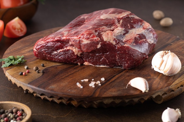 Surowe świeże mięso przyprawa Ribeye Steak i świeży pomidor na drewnianym tle