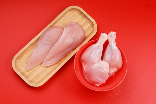 Surowe Udko I Pierś Z Kurczaka Bez Skóry Ułożone W Kuchni Drewniana Deska I Czerwona Miska
