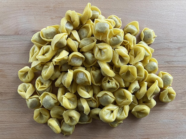 Surowe włoskie tortellini na drewnianym stole