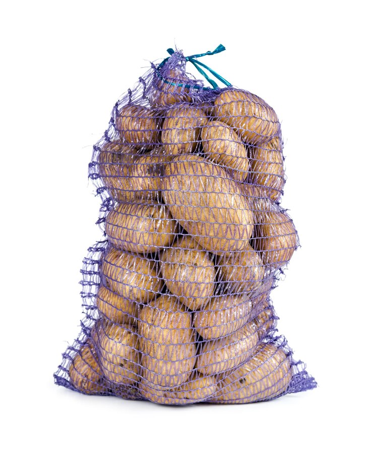 Surowe ziemniaki w worku na białym tle