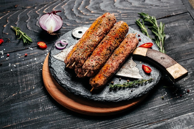 Zdjęcie surowy kebab lula na szaszłykach z ciemnym tłem przypraw lula kebab tradycyjne danie kaukaskie widok z góry