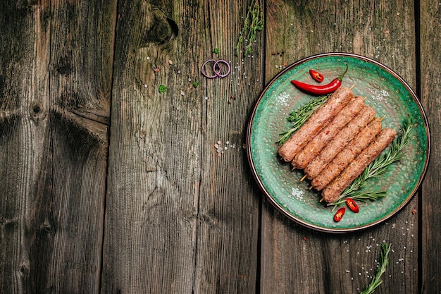 Surowy kebab Lula na szaszłykach z przyprawami na jasnej desce do krojenia Kebab Lula tradycyjne danie kaukaskie Widok z góry w formacie długiego banera