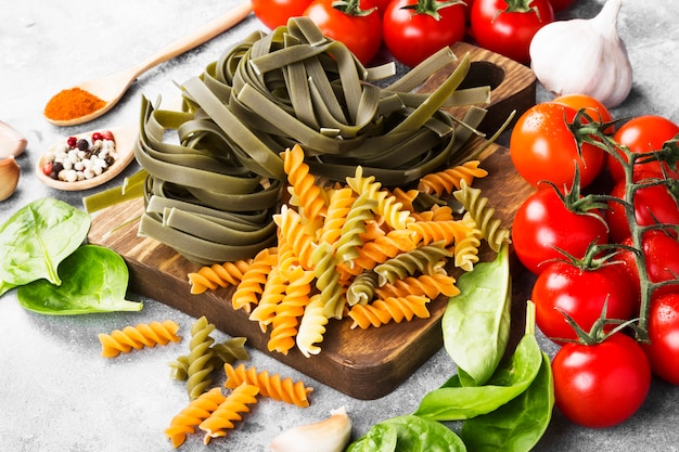 Surowy makaron tagliatelle ze szpinakiem i makaronem Fusilli ze szpinakiem i pomidorami