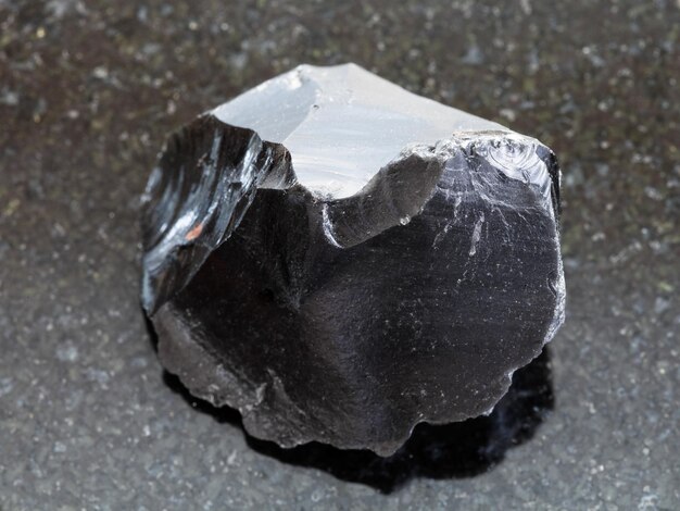 Surowy obsydianowy kryształ szkła wulkanicznego w ciemności
