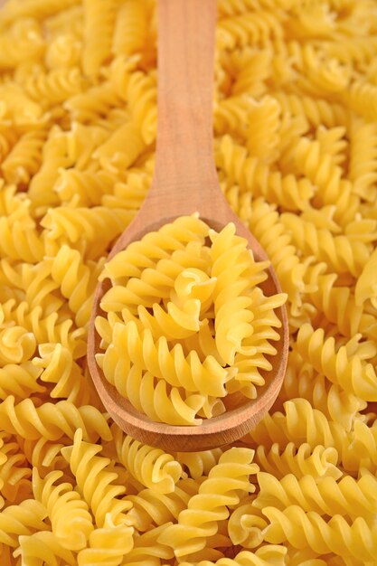 Surowy włoski makaron fusilli w drewnianej łyżce