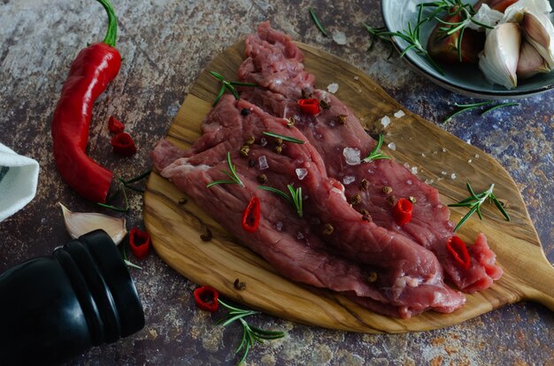 Surowy wołowiny mięso z pikantność na drewnianej desce