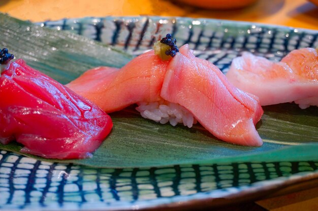 Sushi Chutoro (tuńczyk błękitnopłetwy) podawane ręcznie z marynowanym wasabi. Japoński luksusowy posiłek.