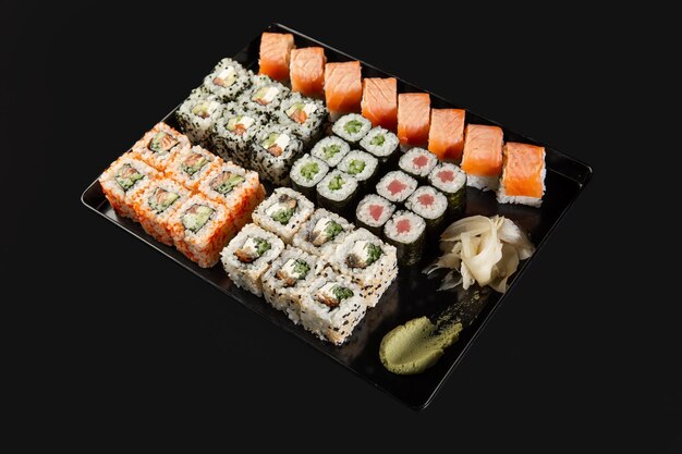 Sushi i krewetki smażone w czosnku na kamiennym talerzu z czarnym tłem