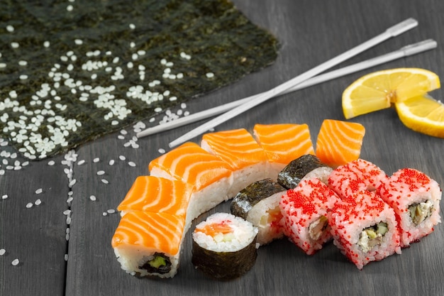 Sushi i rolki z łososiem na drewnianej desce