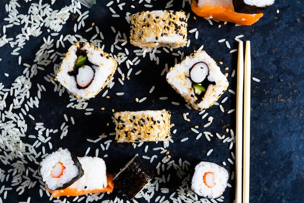 Zdjęcie sushi na czarnym talerzu z drewnianymi pałeczkami jedzenie japońskiego jedzenia w restauracji