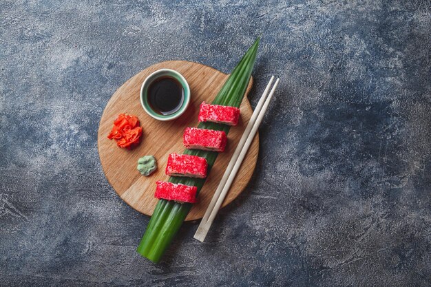 Zdjęcie sushi na drewnianej desce z kamiennym tłem