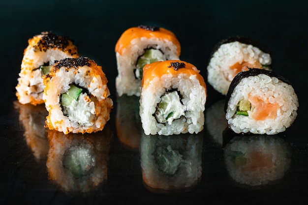 sushi rolki łosoś, warzywa, imbir, ryż wasabi i nori na stole