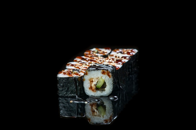 Sushi roll na czarnym tle refleksji japońskie jedzenie bliska