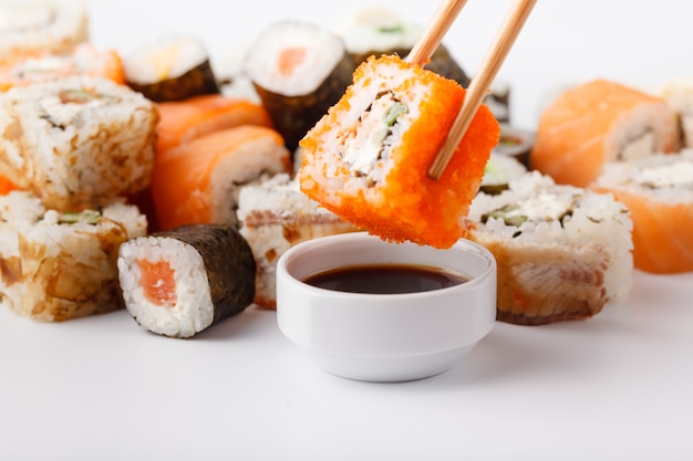 Sushi Roll z łososiem, węgorzem, tuńczykiem, awokado, twarogiem Philadelphia, kawior tobica, chuka. Menu sushi. Japońskie jedzenie na stole