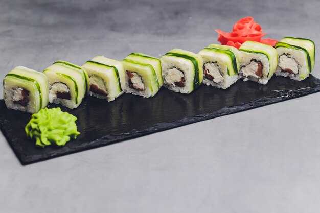 Sushi roll z ogórkiem, sezamem i serem Philadelphia. Japońskie jedzenie. Tradycyjne sushi. Widok z góry.