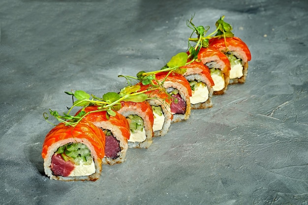 Sushi roll z tuńczykiem, łososiem, ogórkiem i serkiem na szarym tle Selective Focus Sushi Menu