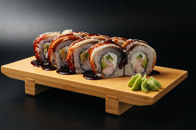 sushi roll z węgorzem i krewetkami na drewnianej desce