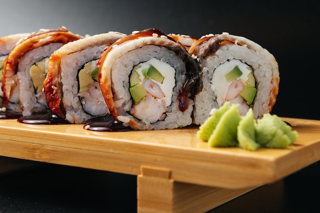 sushi roll z węgorzem i krewetkami na drewnianej desce