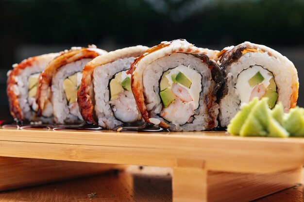 sushi roll z węgorzem i krewetkami na drewnianej desce