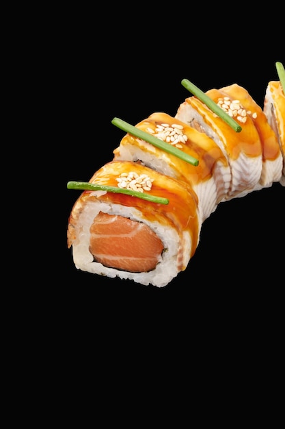 Sushi roll z węgorzem łososiem Japoński majonez unagi sos sezamowy na białym tle na czarnym tle