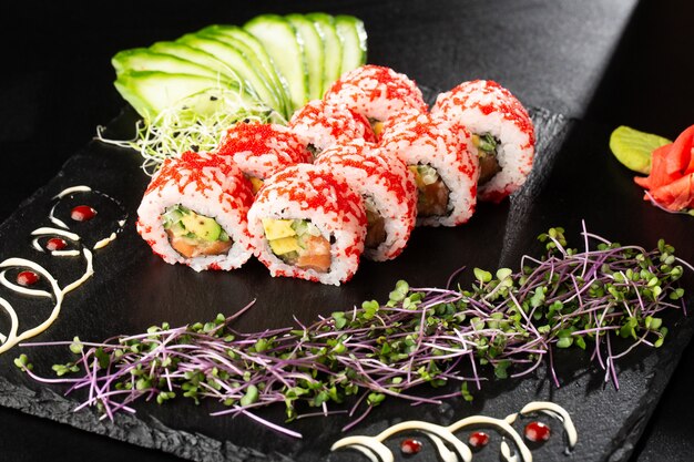 Sushi Rolls z awokado, ogórkiem i łososiem w środku na czarno