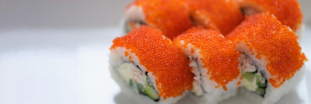 Sushi z pomarańczowym kawiorem latającej ryby na białym talerzu